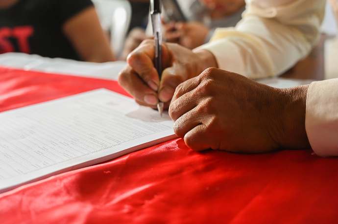 persona rellenando documento en blanco con bolígrafo